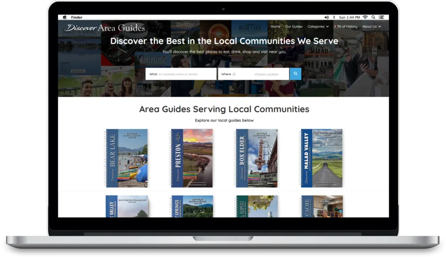 DiscoverAreaGuides.com on a laptop screen, showing a search bar and a row of guide covers.